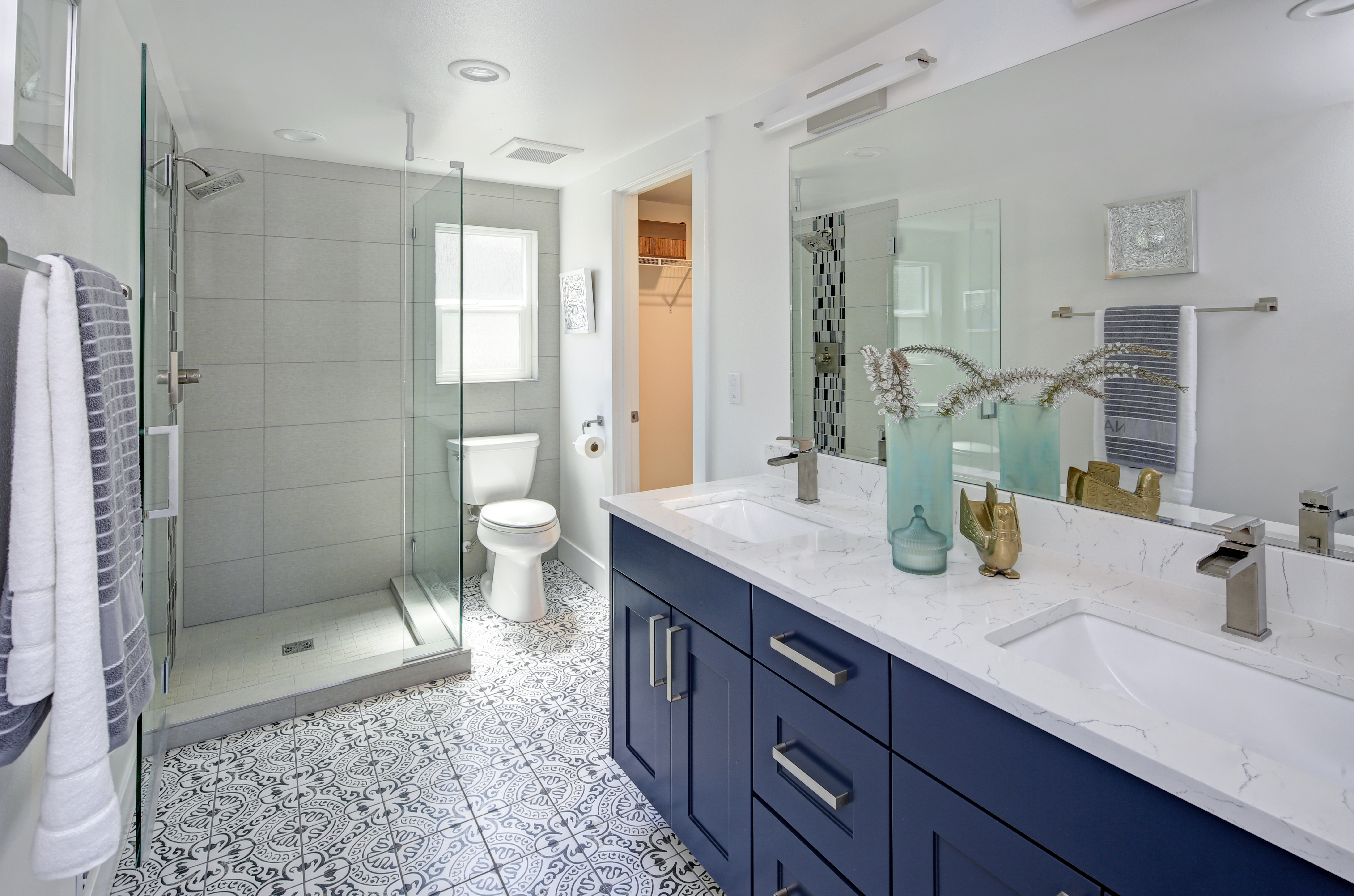 Modern bathroom interior with blue double vanity and glass shower | Carpet Barn